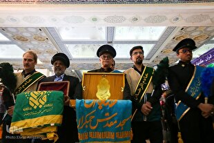 پرچم‌گردانی خادمان حرم امام رضا(ع) در نمایشگاه قرآن + عکس